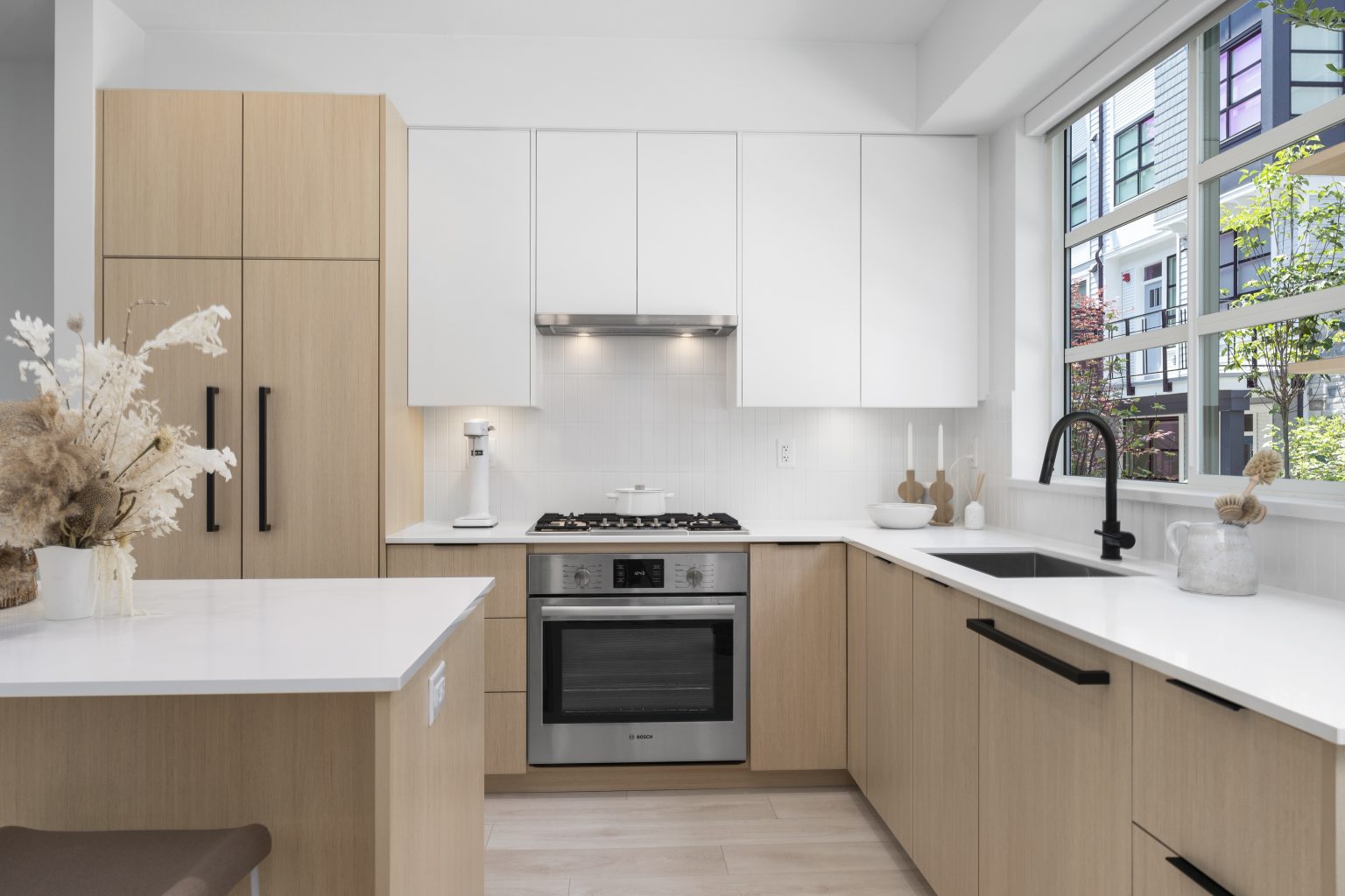 Modern kitchen interior with light wood cabinets and white countertops